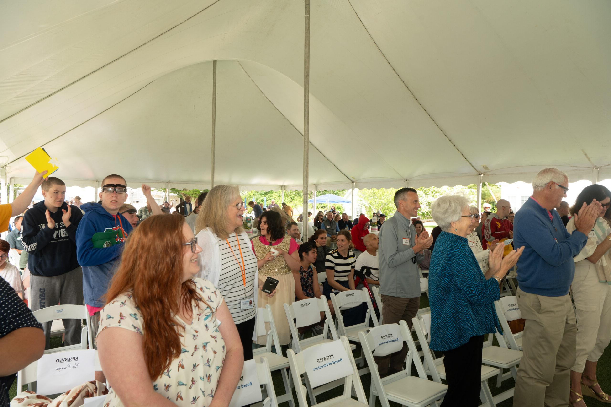 Group of people under a tent during an event.